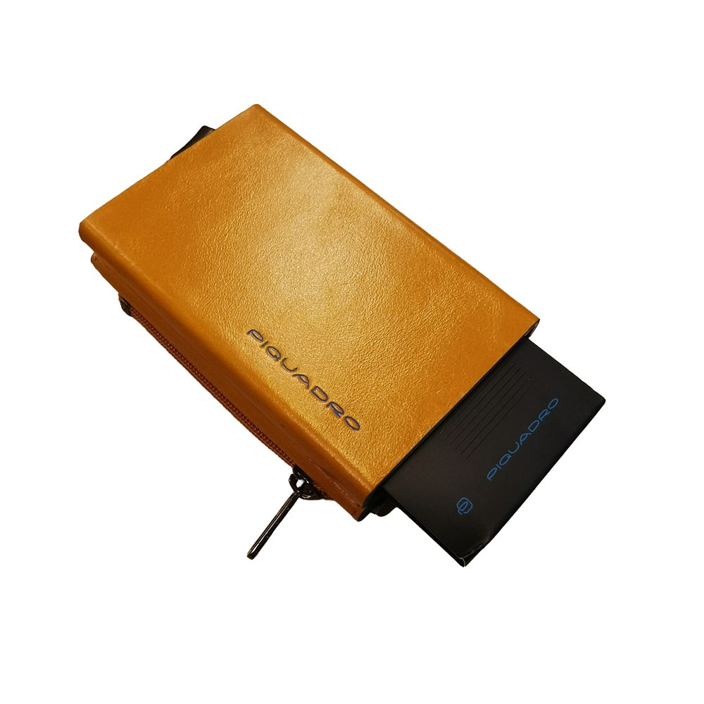 Portafoglio compatto, porta carte con pratica tasca con zip in cui riporre le monete, di Piquadro. Piccolo, leggero, realizzato in morbida pelle con case in alluminio e protezione RFID.
