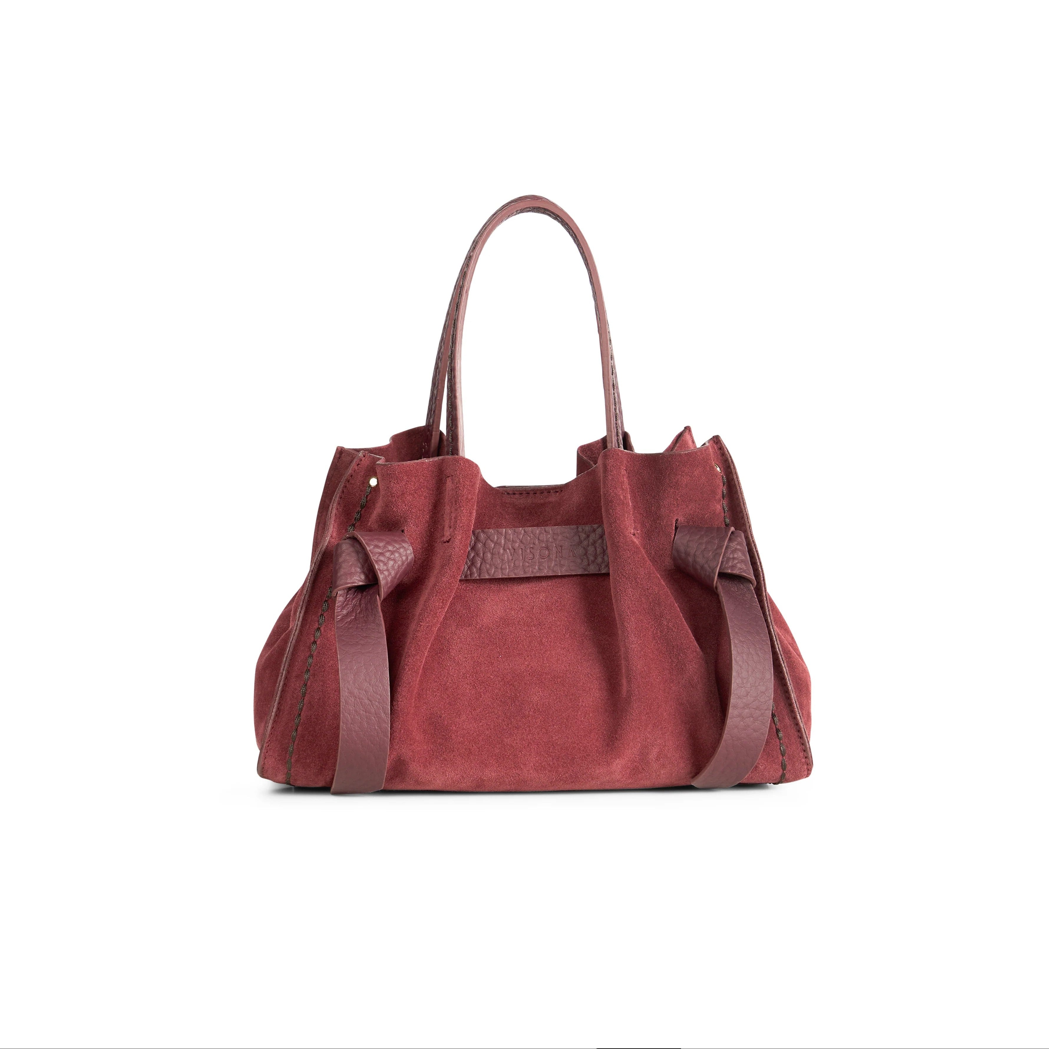 Borsa a mano di piccole-medie dimensioni con fiocchetti in pelle regolabili e tasca interna con zip. 100% Made in Italy.