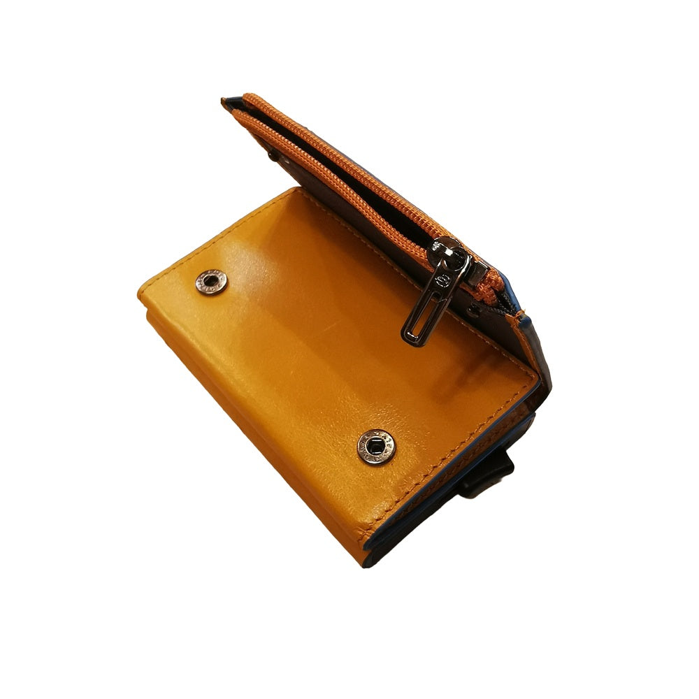 Portafoglio compatto, porta carte con pratica tasca con zip in cui riporre le monete, di Piquadro. Piccolo, leggero, realizzato in morbida pelle con case in alluminio e protezione RFID.